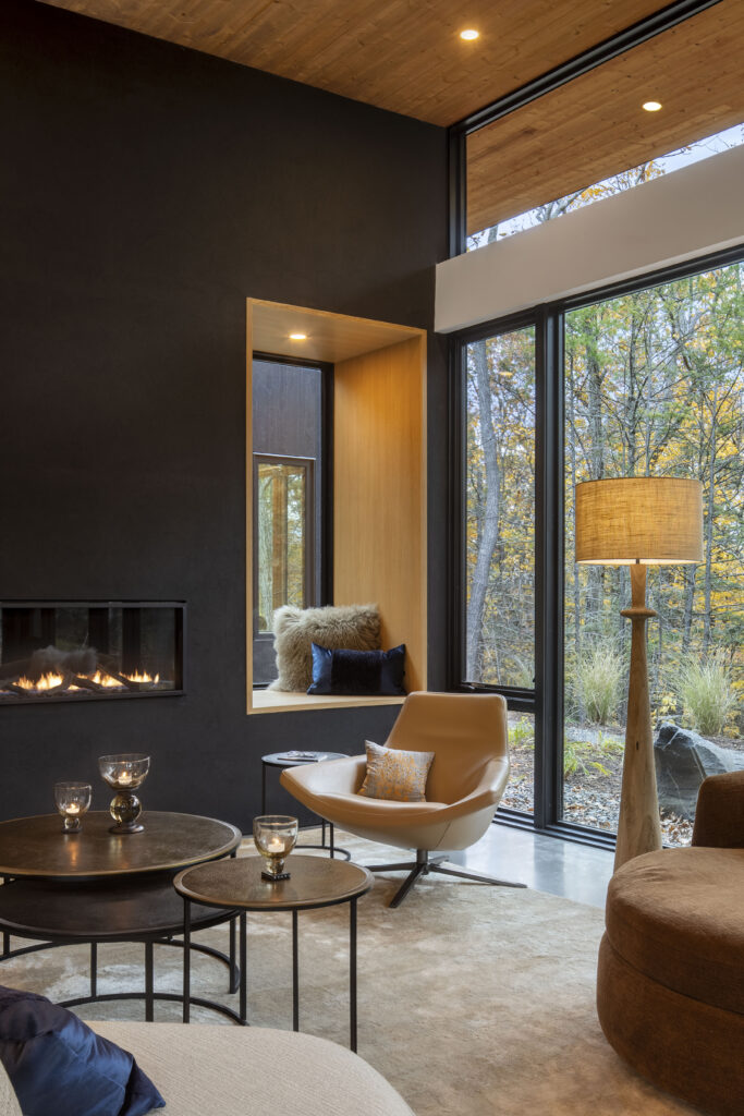 A window seat at Fermata lined in white oak and surrounded by black stucco.