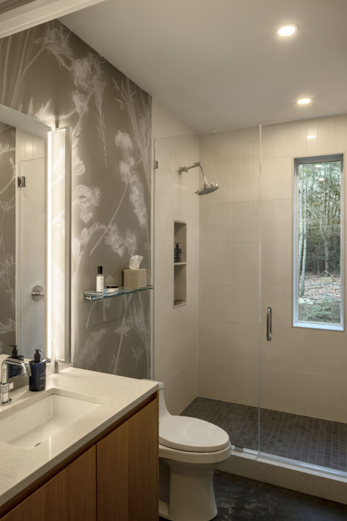 Fermata includes a clean, white bathroom with feature wallpaper and a window that looks out to the trees beyond.